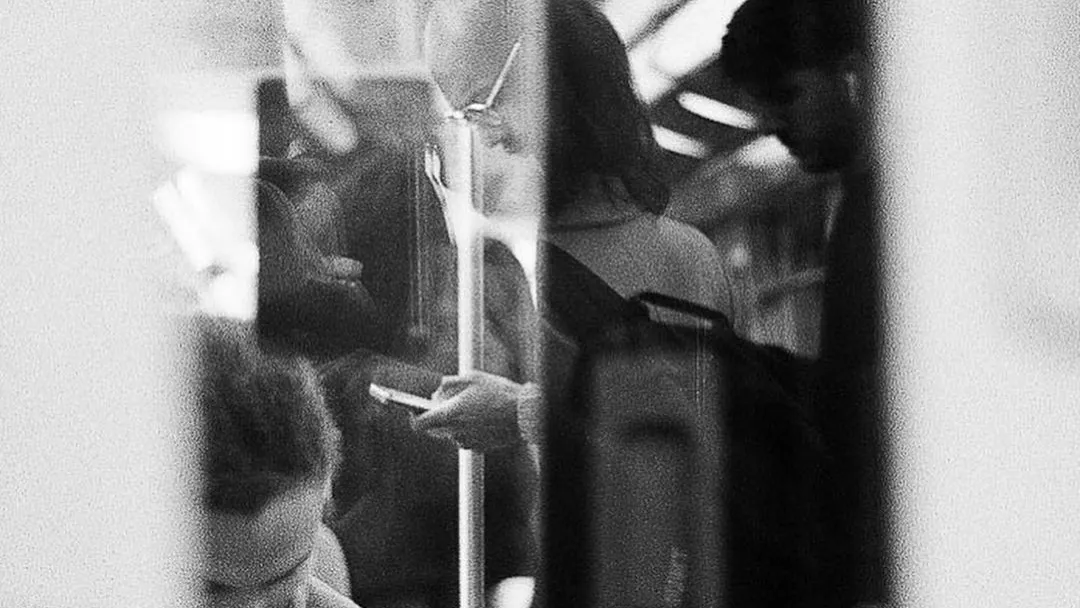 People on the underground busily checking their phones.